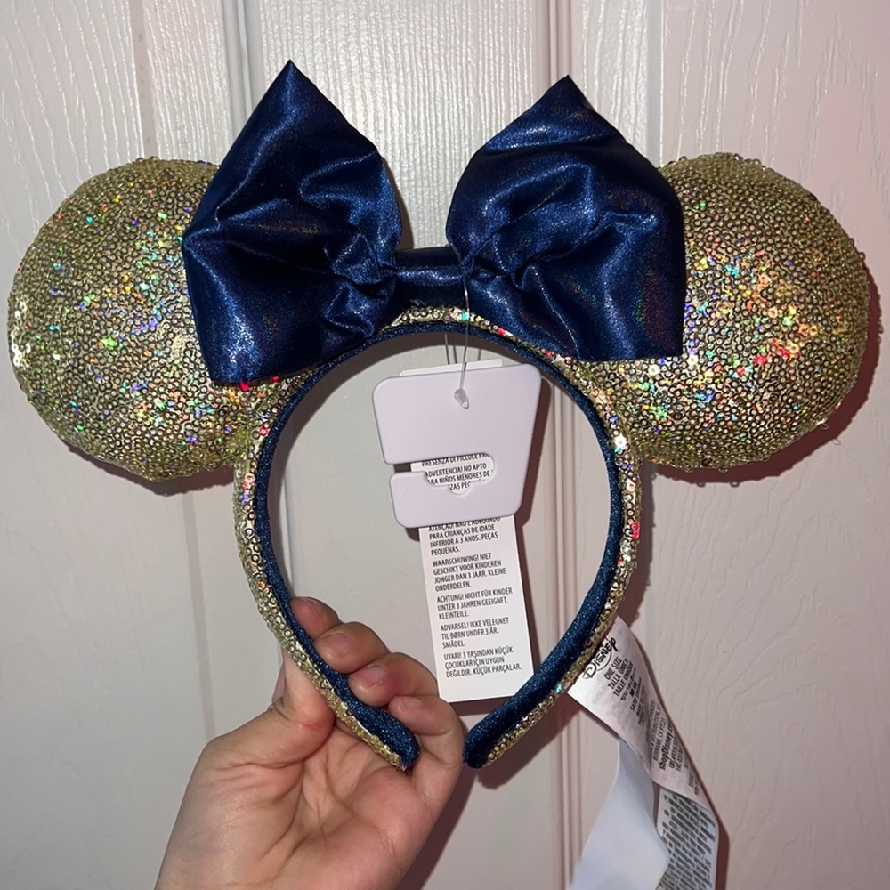 NWT 50th Anniversary Minnie Ears Gold sequenced ears with navy blue bow.